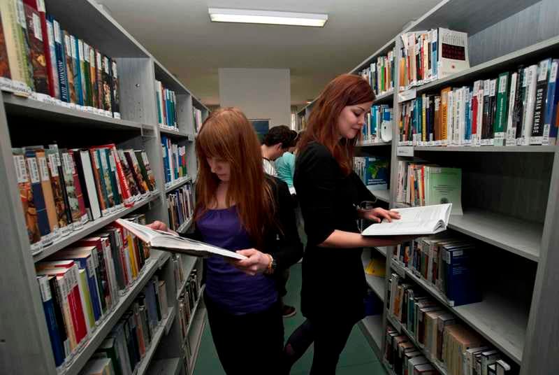 Students researching university options in a library